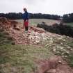 Detail of erosion to SW side of cairn; Mrs Angela Gannon (RCAHMS) in picture