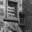 Detail of window with roll moulded surround and window in angle above tower house doorway.