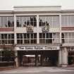 View from NW of main entrance to works, showing gates and security building, an addition (possibly dating from 1970s) due to be demolished in 1995. The old crests relate to the Gates Rubber Company's Royal Warrant.