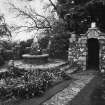View of E garden gate and ornamental seat.