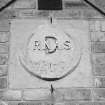 Donibristle airfield, detail of date plaque on gable end of South entrance (building D) to officers' mess.  The plaque has been made of moulded concrete.