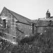 View of mill from SE, showing mill range (left) and kiln (right), also showing the water wheel on the SE gable of the mill.
