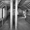 Interior.
View at upper level of mill, showing two pairs of millstones in background.