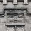 Detail of carved date panel with shield above archway on north front