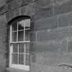 Detail of S front basement arched window and droved ashlar stonework