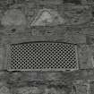 Detail of ornate cast-iron iron vent in wall at E corner of steading.