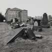 View from E showing apse and vestry wing within vandalised graveyard