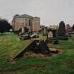 View from E showing apse and vestry wing within vandalised graveyard