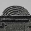 Detail of pediment above niche on outside of north wall.