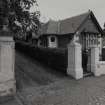 View of gatepiers and lodge from NW