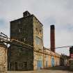 View from SW of W end of boiler-house range, with former still house in foreground, and chimney (centre)