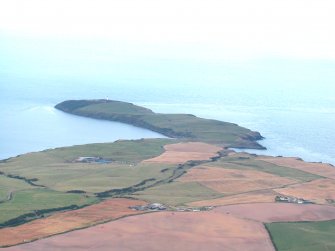 General oblique aerial view centred on the Mull of Galloway earthwork with the lighthouse in the distance, taken from the NNW.