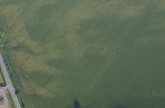 Oblique aerial view centred on the cropmarks of pits, a possible enclosure and possible pit-defined enclosure, taken from the WNW.