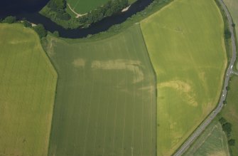 Oblique aerial view centred on the cropmarks of the Roman fortlet and ring-ditches, taken from the SSE.