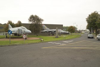 View.  Technical site gate guards, Phantom FRG2 and Tornado F2 with memorial to Norwegian airman who served at leuchars Airfield during World War Two from SW.