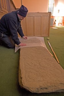 Interior. Mr J Borland making a rubbing of a pictish cross slab