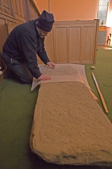 Interior. Mr J Borland making a rubbing of a pictish cross slab