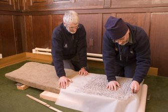 Interior. Mr J Borland and Mr I Parker making a rubbing of a Pictish cross slab