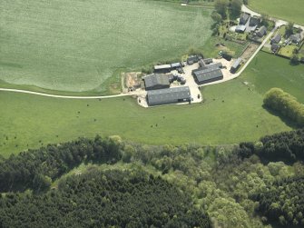 Oblique aerial view centred on the remains of the recumbent stone circle with the farmhouse and farmsteading adjacent, taken from the N.
