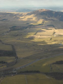 Distant general oblique aerial view looking across the Clyde towards Tinto and the remains of the cairn, taken from the SE.