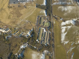 Oblique aerial view of the chicken sheds with the country house and  the remains of the gardens adjacent, taken from the SSW.