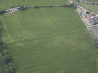 Oblique aerial view centred on the cropmarks of pits, a roundhouse, possible enclosure and rig, taken from the S.