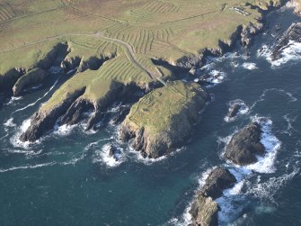 General oblique aerial view centred on the remains of the island settlement with the remains of lazy beds adjacent, taken from the NE.