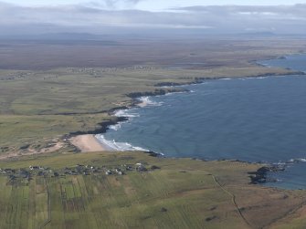 General oblique aerial view looking across the crofting township along the coastline, taken from the NE.