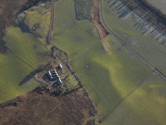 General oblique aerial view of Colmeallie centred on the remains of the stone circle, taken from the NNE.