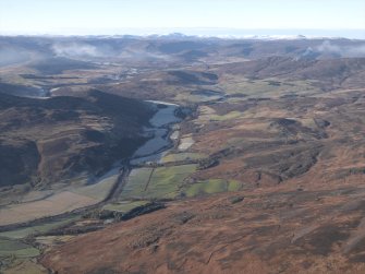 General oblique aerial view looking across Colmeallie and the remains of the stone circle along Glen Esk towards the Grampian mountains, taken from the WSW.