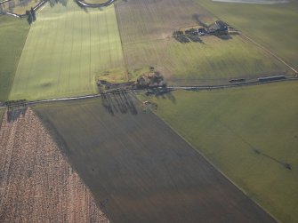 Oblique aerial view centred on the remains of the recumbent stone circle with the farmsteading adjacent, taken from the NE.