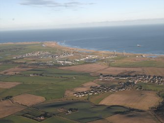 General oblique aerial view looking across the village towards the gas terminal, taken from the SW.