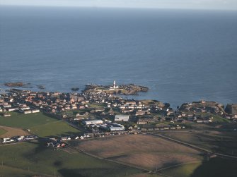 General oblique aerial view looking across the barracks, houses and village towards the lighthouse, taken from the W.