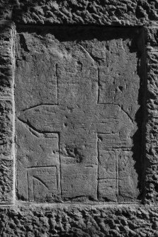 View of medieval grave slab built into W gable of church (B&W)