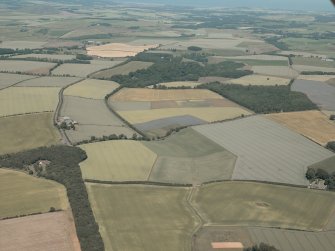 General oblique aerial view looking across the farmhouse and farmsteading to the East Lothian plain, taken from the SW.