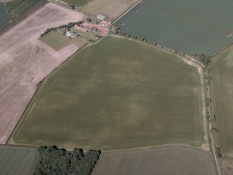 Oblique aerial view centred on the cropmarks of the settlement and field boundaries with the farmhouse and farmsteading adjacent, taken from the NNW.