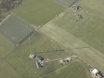 Oblique aerial view centred on the remains of the radar station, pillboxes and the mast, taken from the S.