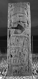 View of rear face of slab with pictish carvings including horsemen, men in boat, crescent and V rod and double disc and Z rod
