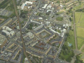 Oblique aerial view centred on the church and housing, taken from the WNW.