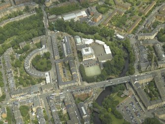 General oblique aerial view centred on the academy, bridge and housing, taken from the SSW.