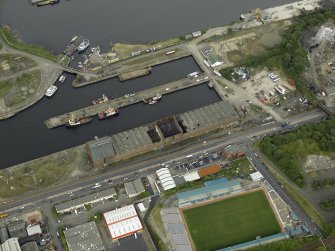 Oblique aerial view centred on the burnt out sugar warehouse and the docks, taken from the SW.