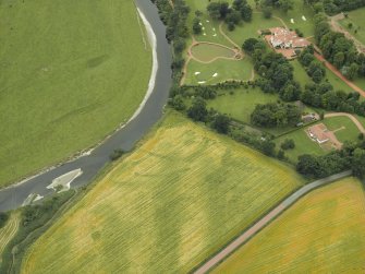 Oblique aerial view centred on the cropmarks of the fort and possible causewayed enclosure with the house adjacent, taken from the ENE.