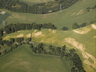 Oblique aerial view centred on the cropmarks of the Roman fortlet, Roman temporary camp and settlement, taken from the SW.