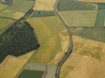 Oblique aerial view centred on the cropmarks of the fort, taken from the WNW.