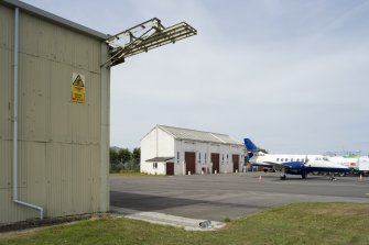 View.  Bellman type aircraft hangar withTriple Turret Trainer, type A in back ground. .  Detail of door gantry from SW.