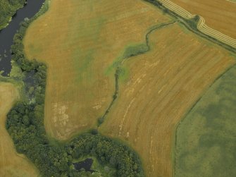 Oblique aerial view centred on the cropmarks of the settlement and enclosure, taken from the NW.