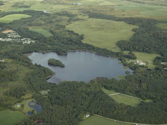 General oblique aerial view centred on Lochnaw Loch and towerhouse, with the towerhouse and country house adjacent, taken from the NW.