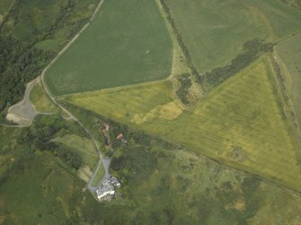 Oblique aerial view centred on the cropmarks of possible ring ditch and pit with the house adjacent, taken from the SW.
