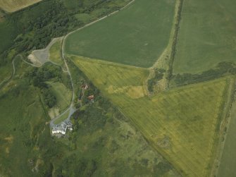 Oblique aerial view centred on the cropmarks of possible ring ditch and pit with the house adjacent, taken from the SSW.
