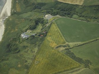 Oblique aerial view centred on the cropmarks of possible ring ditch and pit with the house adjacent, taken from the SSE.
